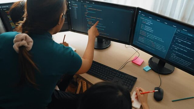 Slow motion back end software developer engineer for computer programming working together on debugging writing computing code, solving complex algorithms display on monitor in office. Burgeoning