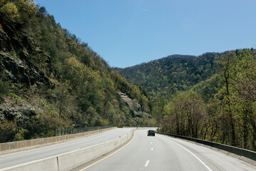 Beautiful landscape with a highway with moving cars among the mountains. Summer in the mountains. Asheville, North Carolina, USA - 13 April 2024