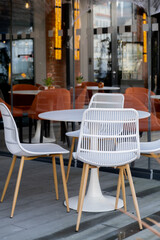 Exterior decor facade of beautiful empty coffee shop in autumn atmosphere. Cozy white armchairs outdoor in street cafe restaurant in Gdansk city Poland