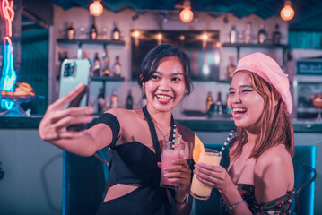 Two teenage women taking a selfie at the bar