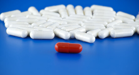 Medical capsule pills scattered on blue background