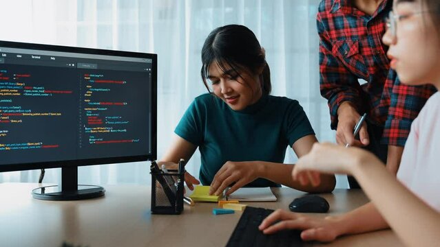 Slow motion back end software developer engineer for computer programming working together on debugging writing computing code, solving complex algorithms display on monitor in office. Burgeoning