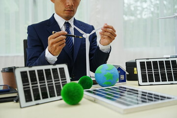 Businessman signs a contract for car insurance in an eco-friendly office. This agreement emphasizes...
