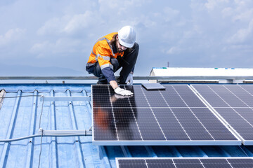 Male professional engineer installing solar photovoltaic panel system, Electrician mounting blue solar module technology on power industrial factory roof, Alternative energy, renewable energy.