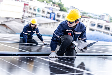 Male professional engineer installing solar photovoltaic panel system, Electrician mounting blue solar module technology on power industrial factory roof, Alternative energy, renewable energy.