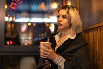 Portrait of a young beautiful blonde girl in an evening spring city.