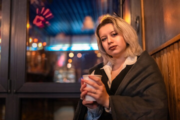 Portrait of a young beautiful blonde girl in an evening spring city.