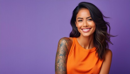 Obraz premium Young brunette woman with arm tattoos isolated on purple background copy space orange shirt cool edgy vibe 