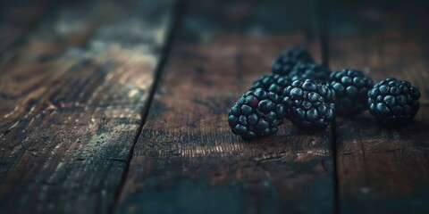 Fototapeta premium A bunch of blackberries are on a wooden table. Generate AI image