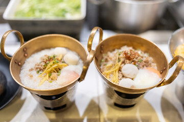 Pork porridge with eggs in a bowl is delicious for breakfast at the reception in a famous chef's kitchen in a 5-star hotel. Prepared with care and with vegetables such as scallions, ginger, and pepper