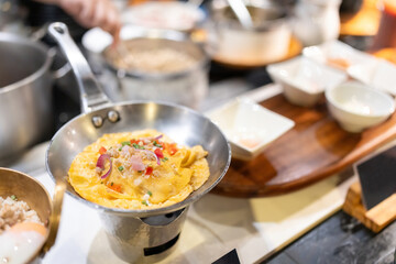 Yummy yellow stuffed omelets are in a pan, ready to be served to hotel guests. Around there are other dishes in the kitchen. Prepared with care by a professional chef.