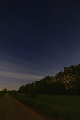 Serene rural nighttime landscape with a starry sky, peaceful and tranquil, showcasing natures beauty under the cosmos