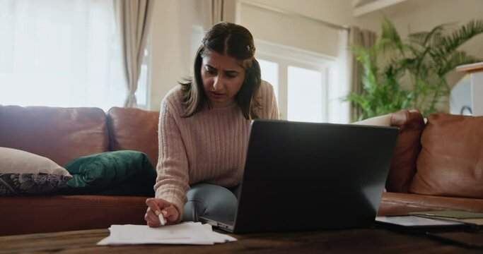 Indian woman, paperwork and laptop with stress for debt on sofa in home with bankruptcy, inflation and overdraft bill. Girl, financial payment and documents with anxiety for online banking and loan