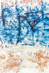 Abstract detailed wall texture with blue graffiti paint.
