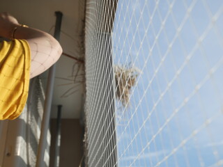 Cleaning dried hay of bird nest at the balcony of the condominium or apartment. Plastic net prevent and protect bird invader.
