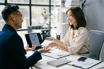 Business Meeting in Modern Office with Smiling Colleagues Discussing Financial Reports and Using Laptop