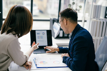 Obraz premium Business Meeting in Modern Office with Colleagues Analyzing Financial Data on Laptop