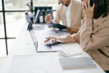 Business Professionals Working on Laptops and Discussing Projects in a Modern Office Environment