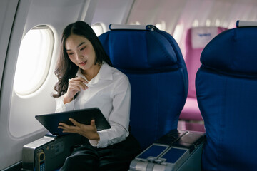 Businesswoman Using Tablet on Airplane, Comfortable Travel, In-Flight Entertainment, Modern Technology, Professional Journey