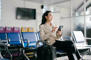 Businesswoman Using Smartphone While Waiting in Airport Lounge with Luggage