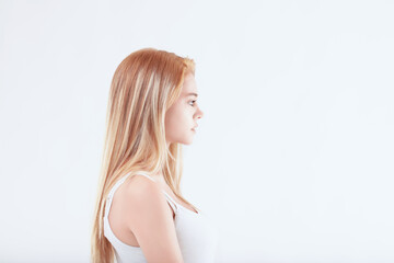 Fototapeta premium Young woman with long blonde hair showing neutral facial express