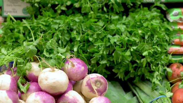 Close-up of fresh organic parsley and turnips displayed in a grocery store. Perfect for illustrating healthy eating, organic produce, and grocery shopping. High quality 4k footage
