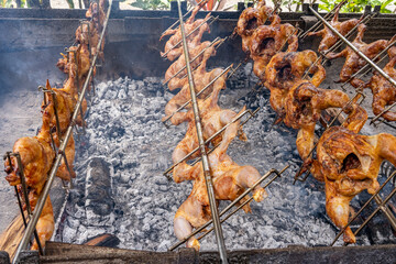 Cooking huli-huli chicken en masse on an outdoor grill,  Huli-huli chicken is a grilled chicken dish in Hawaiian cuisine, prepared by barbecuing a chicken over mesquite wood, Honolulu, Oahu, Hawaii