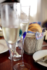 Two glasses of champagne or cava with blurred basket of bread.