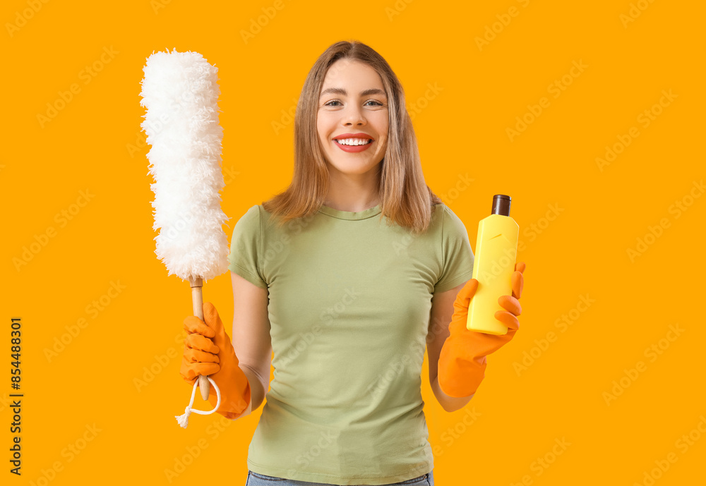 Sticker Young woman with bottle of detergent and pp-duster on orange background