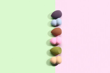 Different makeup sponges on colorful background