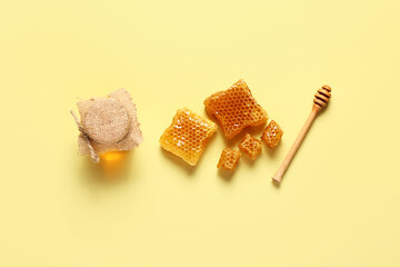 Jar of sweet honey and combs on yellow background