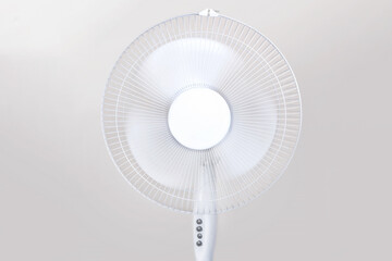 Electric Floor fan turned on white isolated on beige background. Relief Help from the heat, hot...