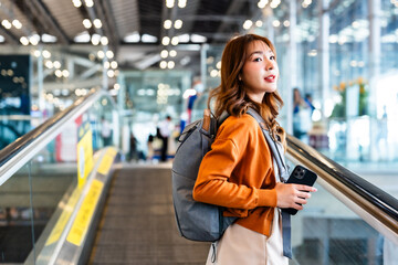 Young asian woman in international airport terminal or modern train station. Backpacker passenger...