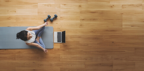 High angle view of young Asian woman practicing yoga and meditation at home sitting on floor in...
