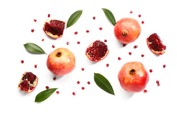 Fresh pomegranates with seeds and leaves on white background