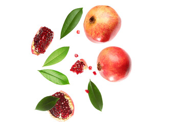 Flying fresh pomegranates with seeds and leaves on white background