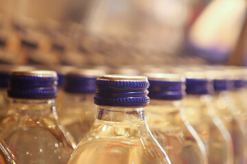 A row of bluecapped bottles is neatly arranged in an industrial factory for manufacturing purposes