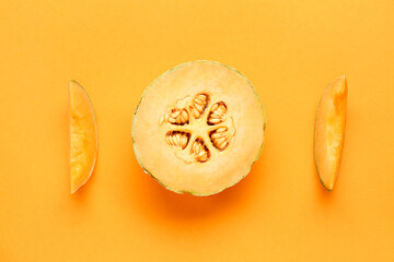 Cut sweet melon on orange background