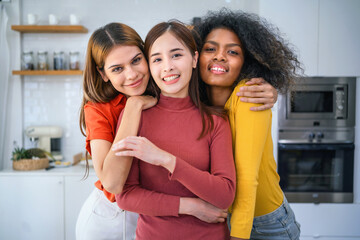 Obraz premium Three women are hugging each other in a kitchen
