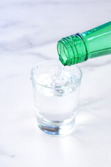 韓国の伝統的な蒸留酒、韓国焼酎（ソジュ）をグラスに注ぐ