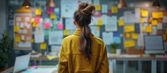 Obraz premium Woman Looking at a Wall of Sticky Notes