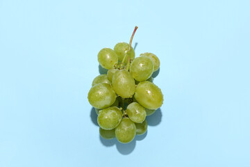 Sweet green grapes on blue background
