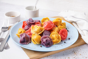 Plate of boiled colorful dumplings with peppercorn on white background