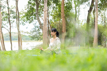 Young woman is meditating at natural park.