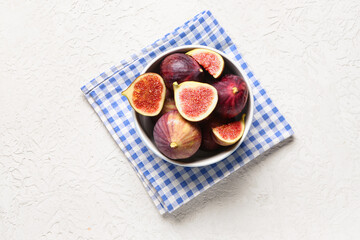 Bowl with ripe fresh figs on textured white background