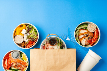 Different poke bowls on blue background top view