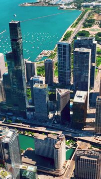 Chicago Illinois aerial shot drone flying through high rise residential and office buildings at New Eastside. Maggie Daley park. Vertical video.