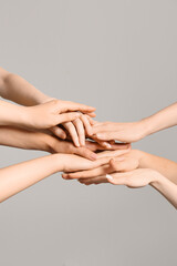 Group of people putting hands together on grey background. Inclusion concept