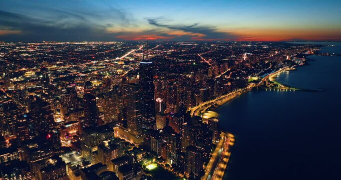 Chicago skyline panorama aerial view with skyscrapers over Lake Michigan with cloudy sky at dusk.