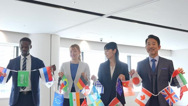 万国旗を持って並ぶ多国籍ビジネスパーソンのグループ